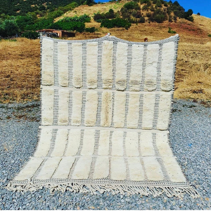 Front view of a cream tufted Moroccan Berber rug featuring geometric patterns in white and beige.