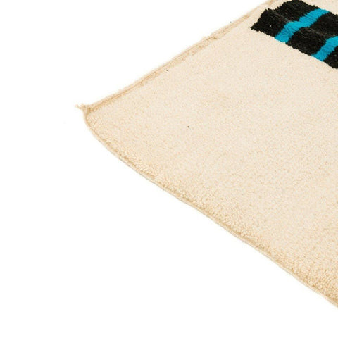 Detail view of the geometric design on the cream tree design rug, showcasing soft textures in cream, black, and blue.