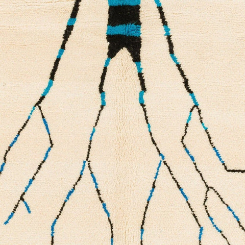 Close-up of the roots on the cream tree design rug, highlighting the abstract patterns in beige, black, and blue.