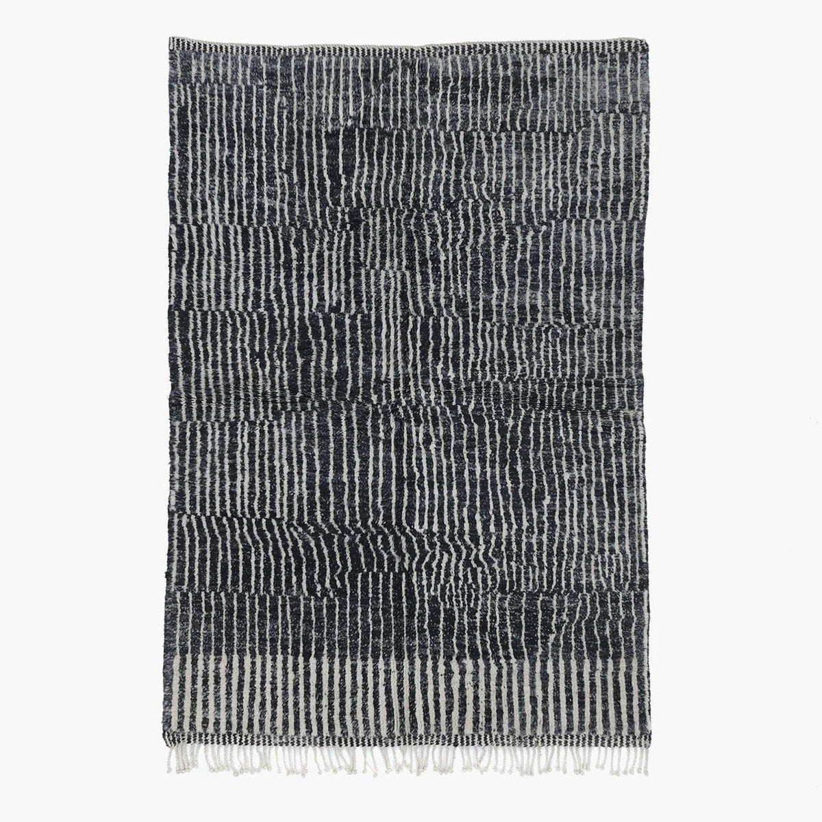 Front view of a black tribal rug featuring an abstract pattern and fringe edges.