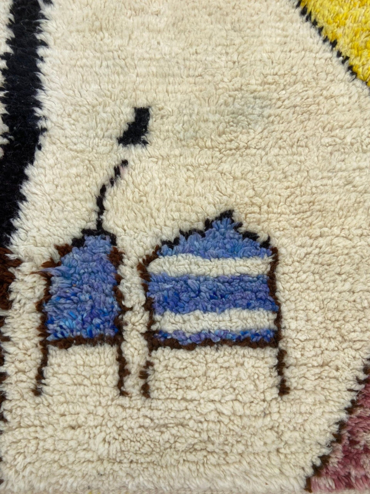 Close-up detail of the handmade texture on a blue and yellow tribal Azilal rug.
