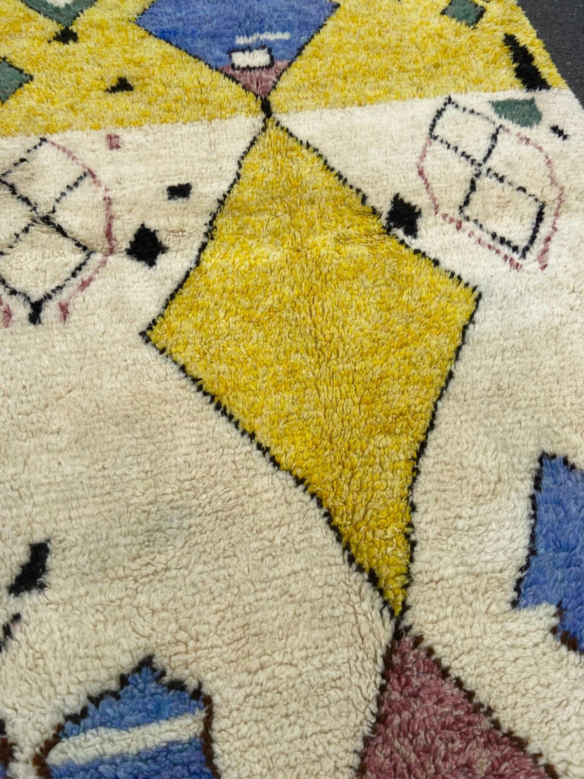 Close-up detail highlighting the geometric patterns on a blue and yellow tribal Azilal rug.