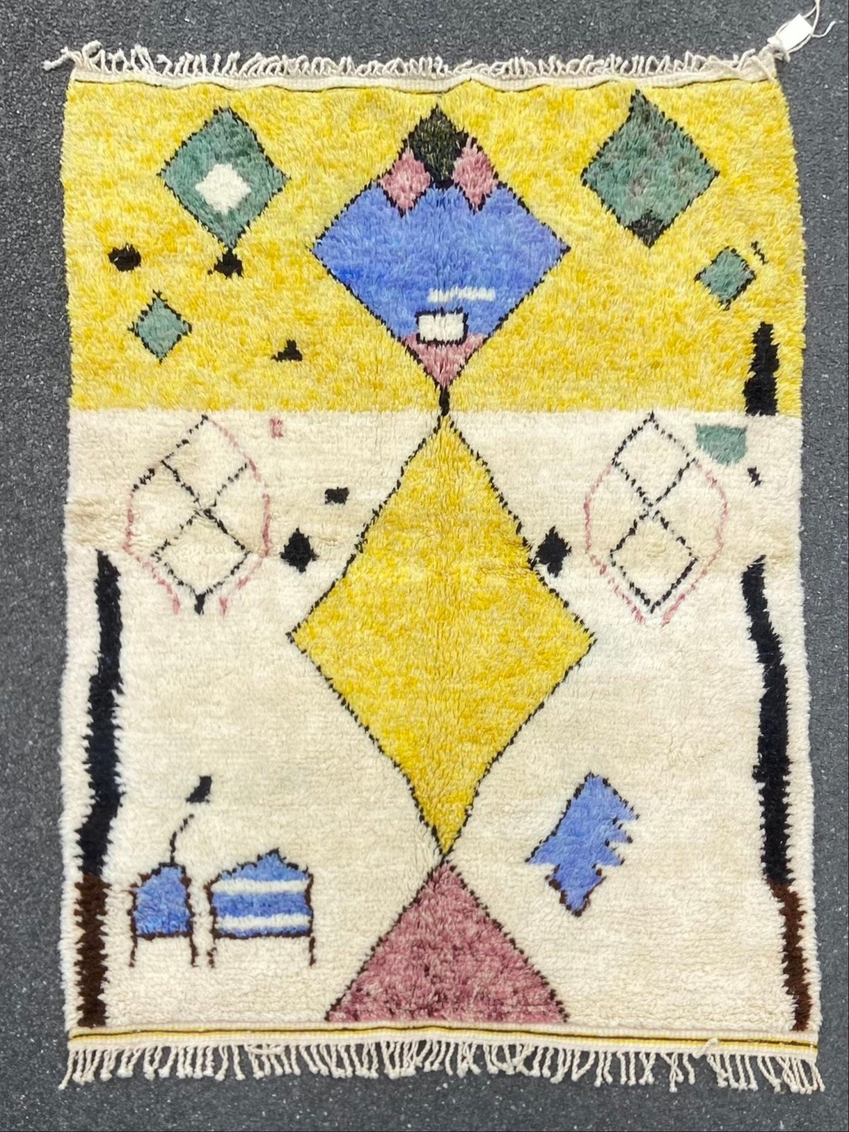 Front view of a blue and yellow tribal Azilal rug with geometric patterns and fringe edges.