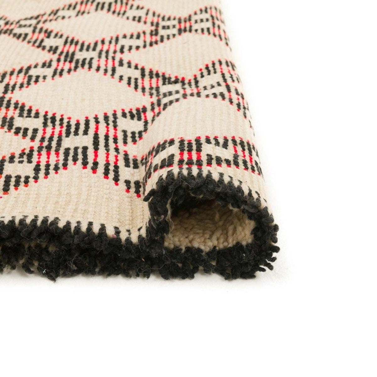 Close-up of the vintage-style Beni Ourain rug featuring a diamond pattern and fringed edges.
