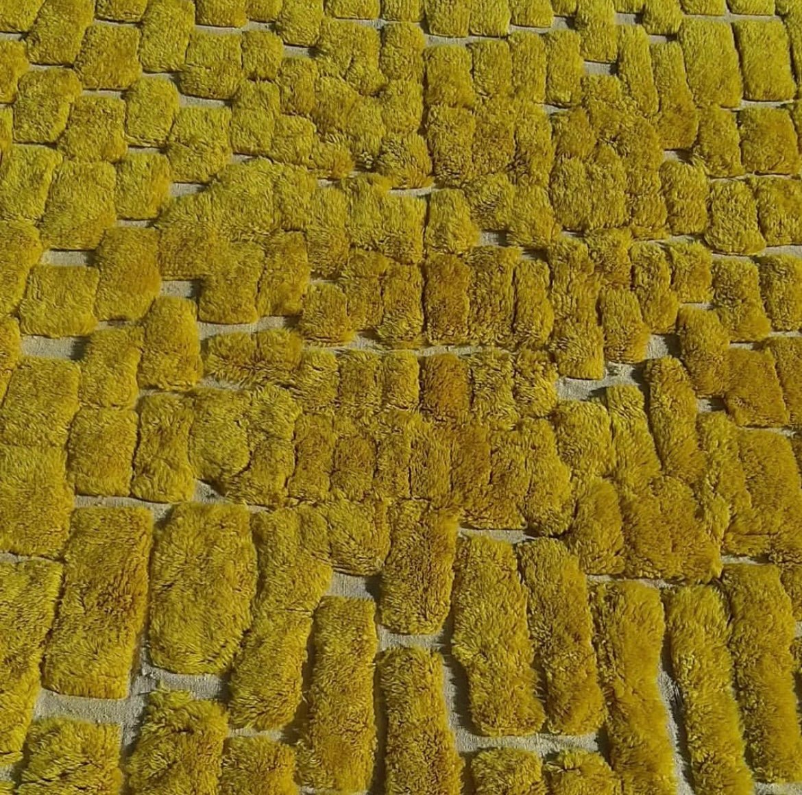Close-up detail of the yellow Berber rug emphasizing its soft texture and vibrant color.