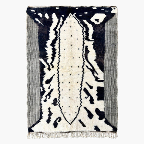 Front view of the black and white zebra print rug with fringe edges on a white background.