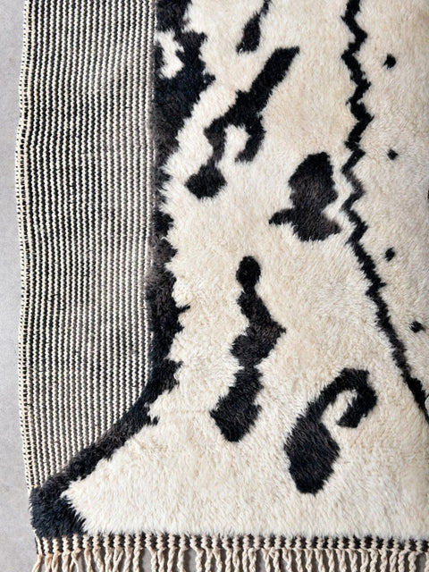 Close-up detail of the zebra print rug displaying an abstract pattern and fringe edges.
