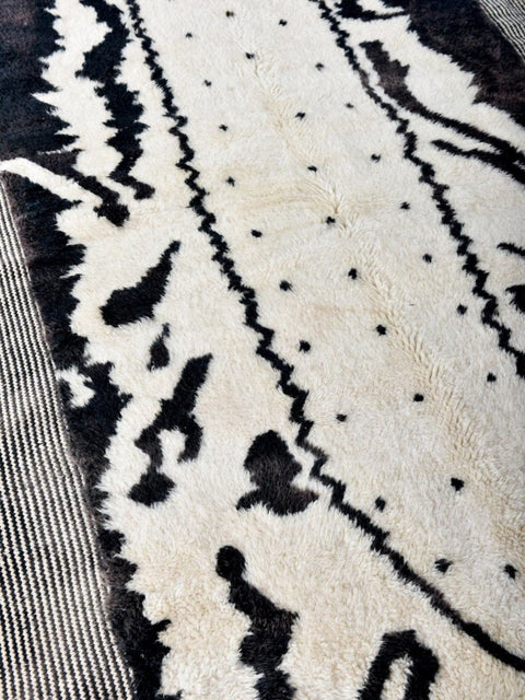 Front view of the black and white zebra print rug featuring abstract design and fringe edges.